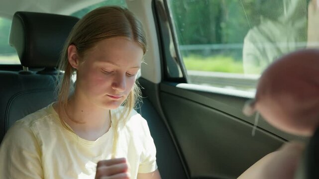 Girl smelling perfume in the back seat of a car slow motion and talking to the other passengers