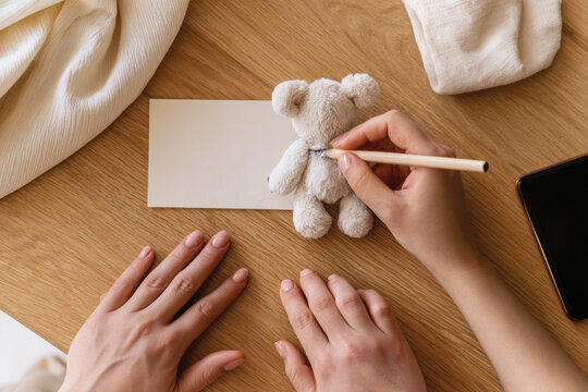 An artisan's hands skillfully draw on a soft plush teddy bear, showcasing the blending of creativity and warmth in handcrafted toy design to enchant children and spark imagination.