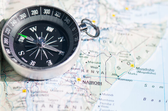 View of a magnetic compass resting on a detailed map of East Africa highlighting Kenya.