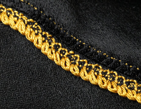 Macro Close Up of Gold Braided Zari Border on Traditional Black Bisht Fabric