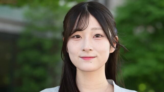 自然の中で笑顔を見せる20代日本人女性のポートレート