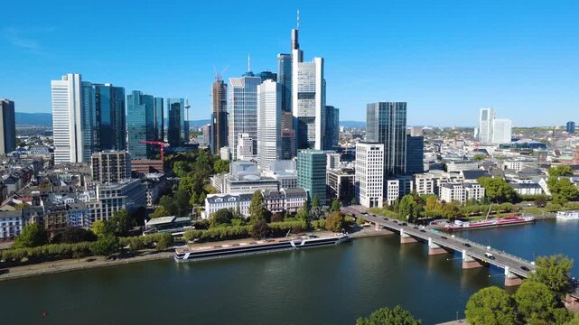 Aerial orbit around Frankfurt financial district with skyscrapers, Main River, busy road bridge and urban traffic. Filmed September 25, 2026.