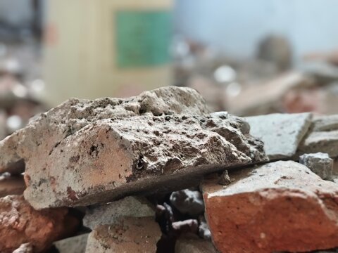 Close up low angle shot of broken concrete brick rubble on construction site with blurred background
