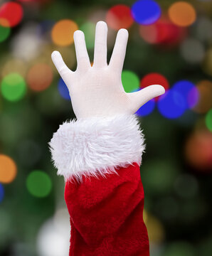 Shot of an Santa Claus palm hand at home with christmas tree