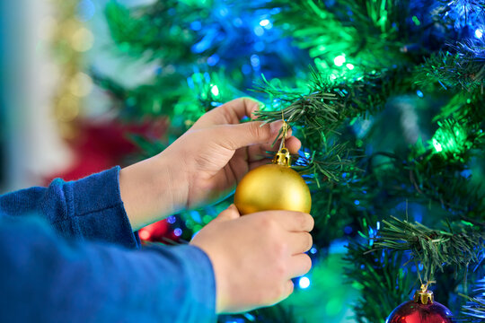 Christmas, ornament and hands of child  with tree decoration on holiday or vacation in home. Festive, celebration and closeup with glass bauble for xmas in house