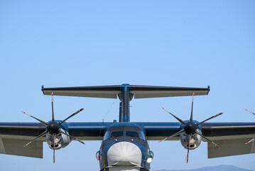 Front view of a turboprop aircraft with propellers and tail section against a clear blue sky © Shohei Kannauchi