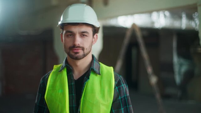 Happy calm Caucasian builder man looking at camera on construction site confident male worker wearing helmet contractor posing engineer architect foreman repair specialist in uniform portrait outdoors