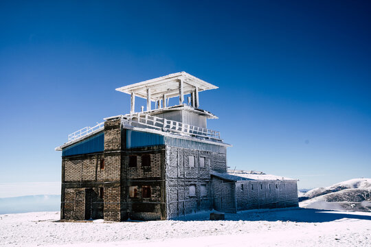 View of the Golyam Kademliya Shelter covered in frost and snow under a clear blue sky in the Balkan Mountains, Stara Zagora, Bulgaria.