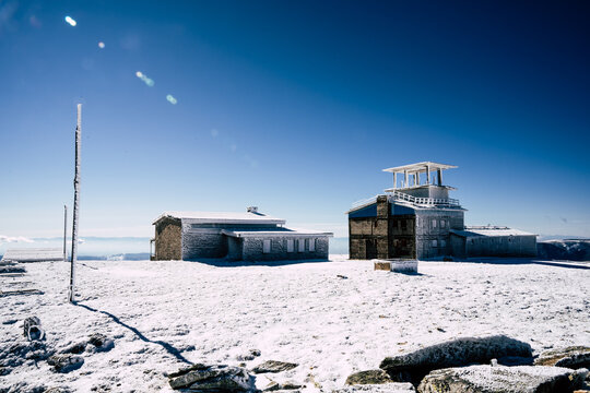 View of the Golyam Kademliya Shelter surrounded by snow-covered terrain under a clear blue sky in Stara Zagora, Bulgaria.
