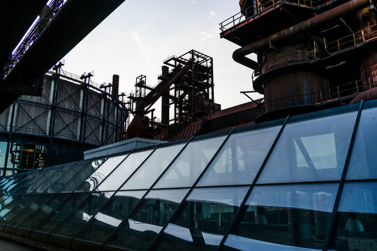View of the industrial architecture and rusted metal structures of the Dolni Vitkovice complex with a modern glass roof in Ostrava, Moravian-Silesian Reg, Czechia.