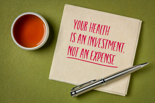 your health is an investment, not an expense, inspirational quote on a napkin with tea