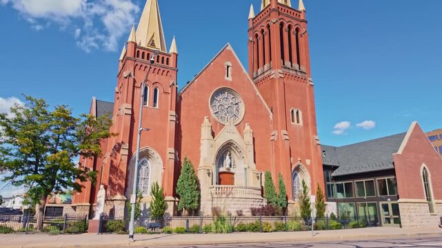 Ornate red brick towers and rose window frame the historic St. Mary's Catholic Cathedral in downtown Colorado Springs