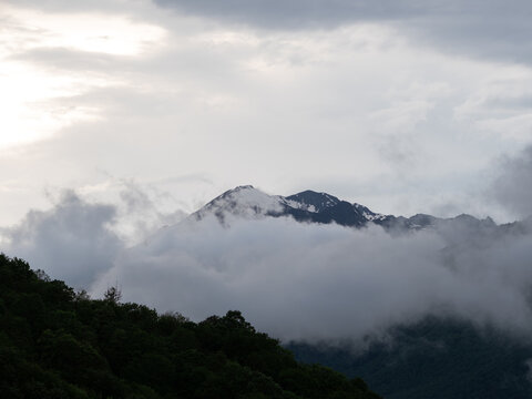 Mountain summit above clouds with glowing light in the sky, heavenly spiritual view