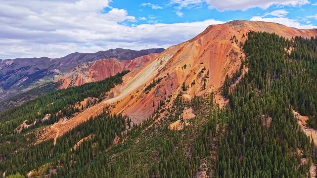 Panoramic aerial view shows historic wooden Yankee Girl Mine headframe amid colorful Red Mountains near Ironton along Million Dollar Highway Colorado