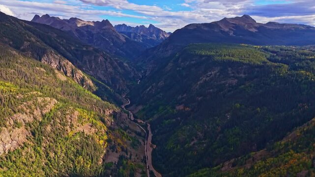 Panoramic aerial sunset illuminates rugged Needles peaks viewed from Molas Overlook along the Million Dollar Highway in Colorado