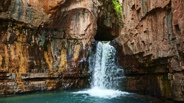 Closeup view of Cascade Creek Falls cascading through rugged canyon walls at dusk near the Million Dollar Highway in Colorado