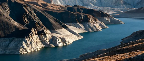 Dramatic Mountain Lake Surrounded by Rugged Rocky Peaks in Sunlight © Jonas Weinitschke
