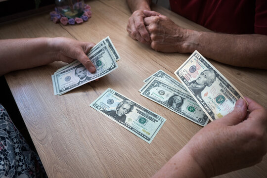 A retired couple divides up US dollars for living expenses.
