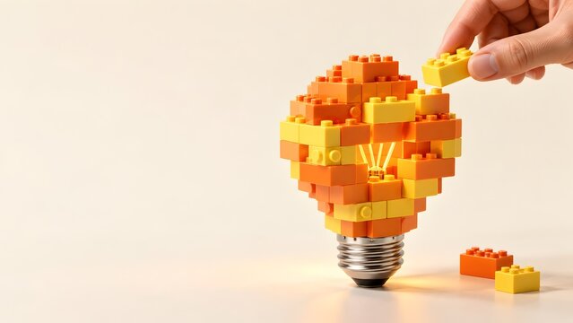 Collaborative innovation concept showing hand assembling glowing lightbulb from colorful toy building blocks representing creative problem solving and team strategy