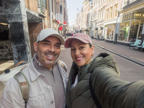 Happy young couple taking a selfie on a street in Amsterdam