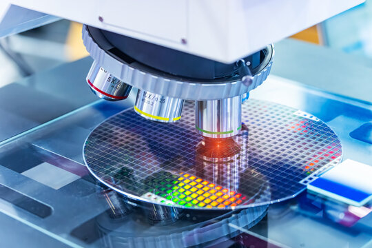 Silicon wafer with semiconductor microchip on machine process examining testing in microscope.