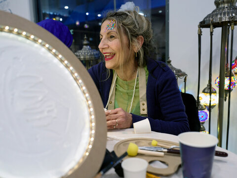 Senior Woman Smiles While Creating Art in a Workshop