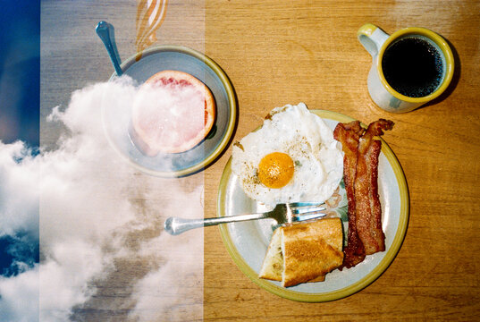 Double exposure of blue sky with clouds and traditional breakfast