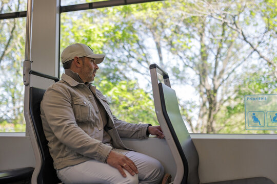 Man sitting and looking out the window inside a clean train
