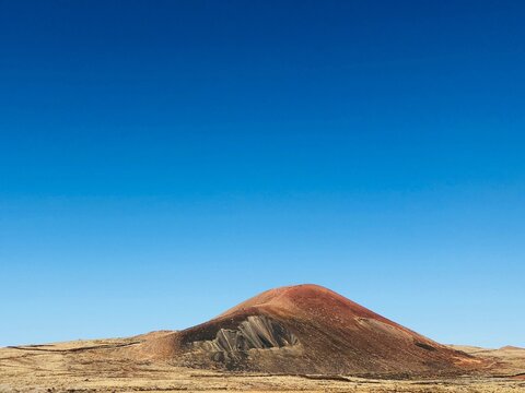 Extinct volcanic cone in an arid desert landscape on a sunny summer day, Timanfaya National Park, Lanzarote, Canary Islands, Spain