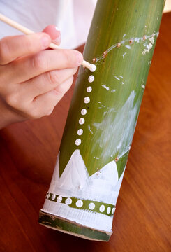 Chinese female teacher hand-painting designs on a thunder tube