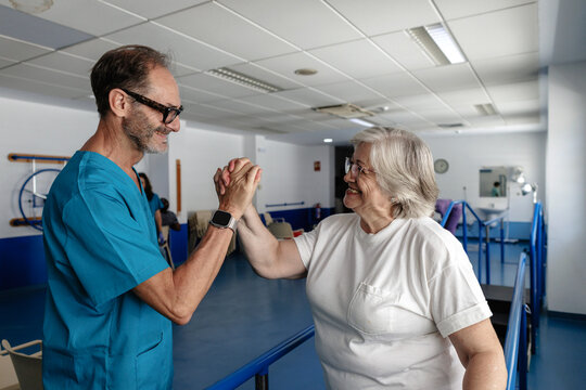 Physiotherapist assisting senior woman achieving