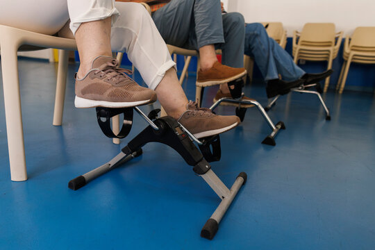 Seniors doing leg exercises with mini pedal exercisers