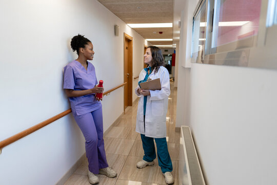 Healthcare professionals discussing work in hospital corridor