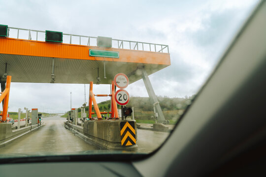 From inside to outside shot of car passing toll road crossing gate