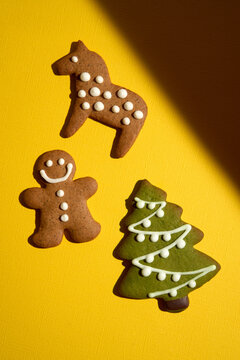 Three Holiday Cookies of Various Shapes on a Bright Yellow Background