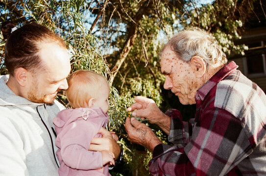 Family shares a moment with a baby in the garden