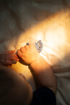 Baby Reaching for Pacifier in Sunlight