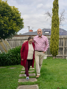 Elderly Couple Walks Together Looking Somber