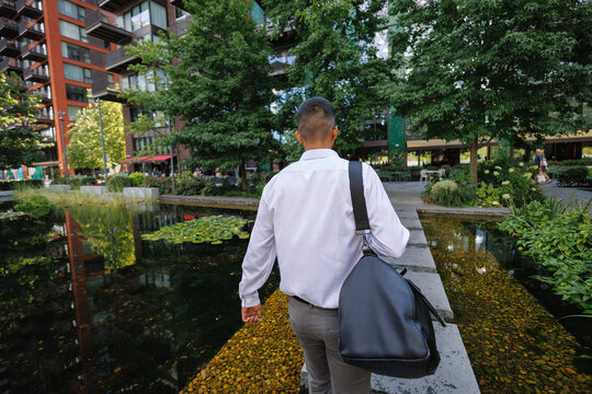 Young businessman walking through urban park