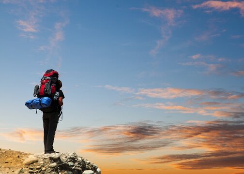 climber or hiker or tourist on sunset sky background