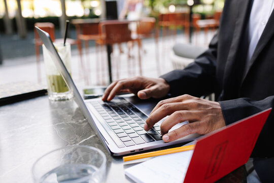 Young businessman typing on laptop outdoors