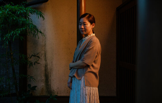Contemplative Woman at a Japanese Courtyard Door at Night