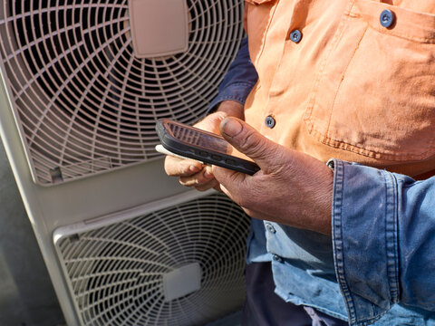 Aircon service person using software on mobile device during service