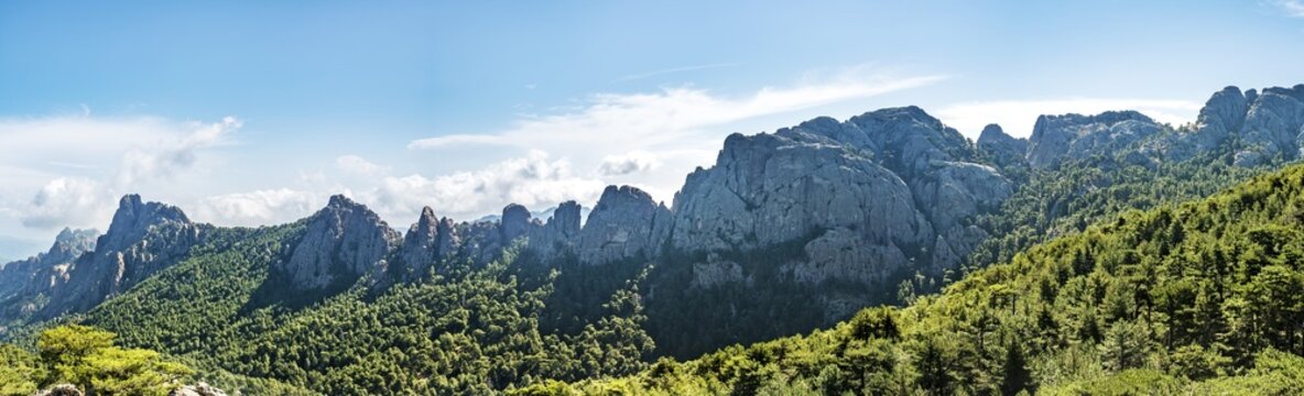 Mountain range with rocky peaks surrounded by pine forest, Col de Bavella, Bavella massif, Corsica, France