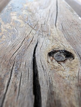 Weathered wooden plank with deep grains and a dark knot, captured in