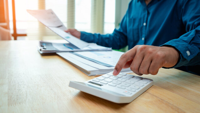 invoice, accounting, finance, payment, billing, calculator,paperwork, financial,Business professional reviewing an invoice and using a calculator for payment, billing, budget and financial accounting