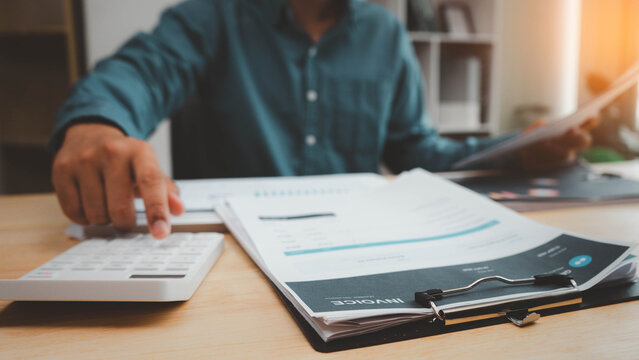 invoice, accounting, finance, payment, billing, calculator,paperwork, financial,Business professional reviewing an invoice and using a calculator for payment, billing, budget and financial accounting