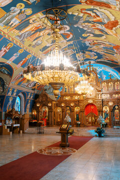 Interior of St. Nicholas Serbian Orthodox Cathedral with ornate chandeliers and frescoes