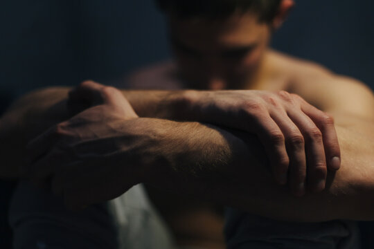 Close-up of a shirtless man with his face blurred sitting on the floor Struggling with Mental health issues
