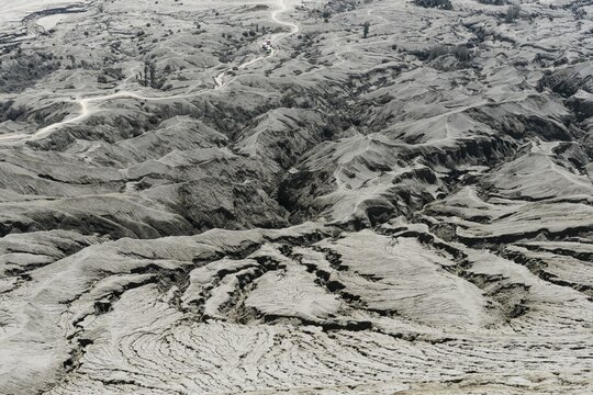 Hostile volcanic landscape, gaps and cracks, dry ground on volcano crater, Mount Bromo, Bromo Tengger Semeru National Park, Java, Indonesia